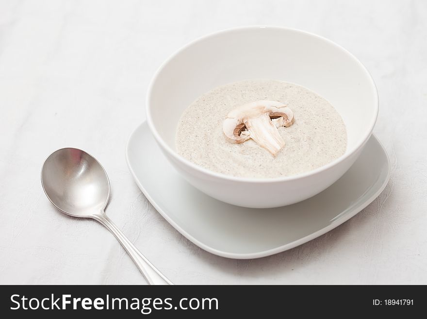 Bowl of mushroom soup with fresh mushrooms