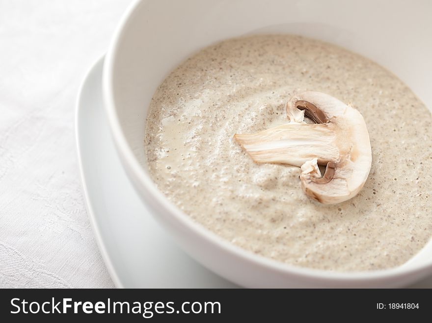 Bowl of mushroom soup with fresh mushrooms