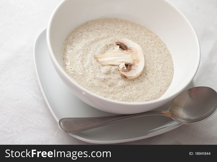 Bowl of mushroom soup with fresh mushrooms