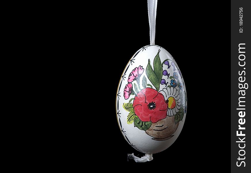 The image shows a hand painted easter egg over black