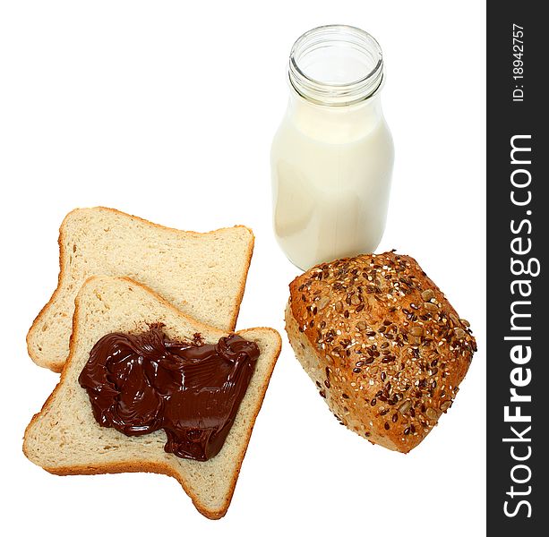 A bottle of milk,two slice of bread with milk chocolate on one of them and whole grain bread isolated on a white background. A bottle of milk,two slice of bread with milk chocolate on one of them and whole grain bread isolated on a white background