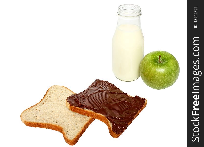 A bottle with milk,green apple and two slices of bread one with spread milk chocolate cream isolated on a white background. A bottle with milk,green apple and two slices of bread one with spread milk chocolate cream isolated on a white background