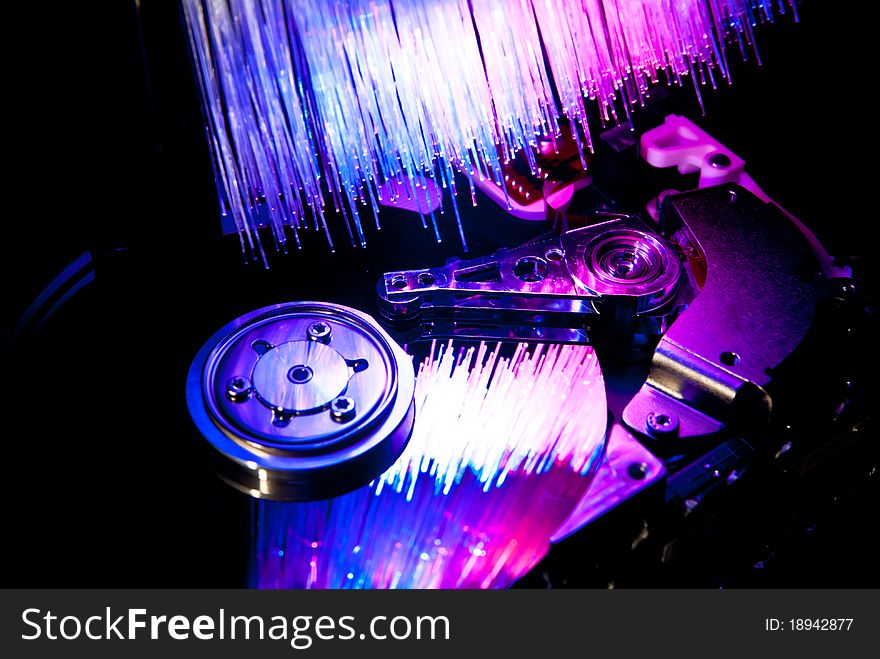 Hard disc with fiber optics background. Studio shot