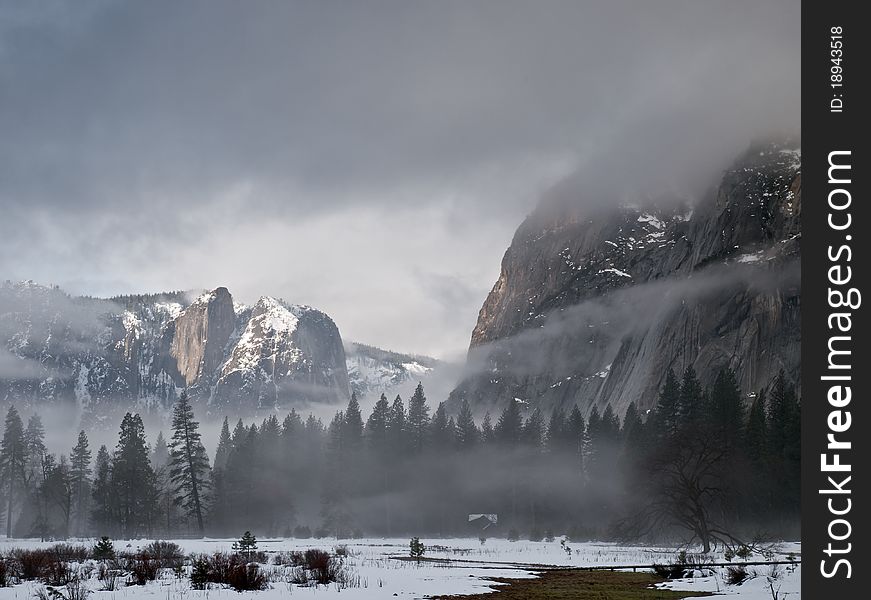 Fog and low clouds rolling in yosemite valley on a cold winter morning,with snow covering the grounds. Fog and low clouds rolling in yosemite valley on a cold winter morning,with snow covering the grounds.