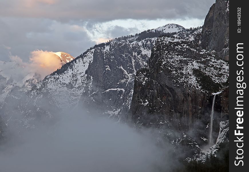 Last sun rays illuminating half dome at yosemite valley on a foogy late afternoon,giving the impression it is on fire,during a snow storm in late winter. Last sun rays illuminating half dome at yosemite valley on a foogy late afternoon,giving the impression it is on fire,during a snow storm in late winter.