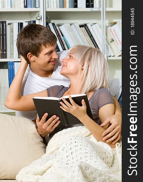 Young couple reading together at home