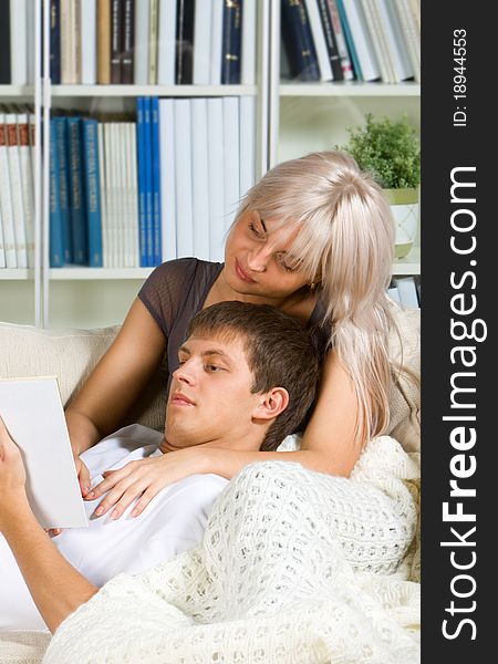 Young couple reading in their bedroom. Young couple reading in their bedroom