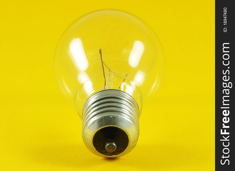 Light bulb closeup over yellow surface