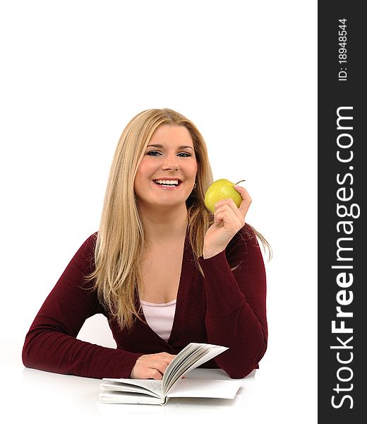 Pretty casual female with green apple reading book