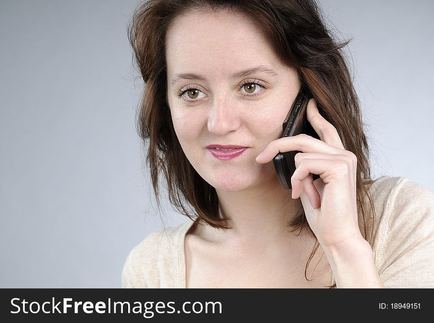 Cute caucasian girl talking on mobile and making gestures. Cute caucasian girl talking on mobile and making gestures