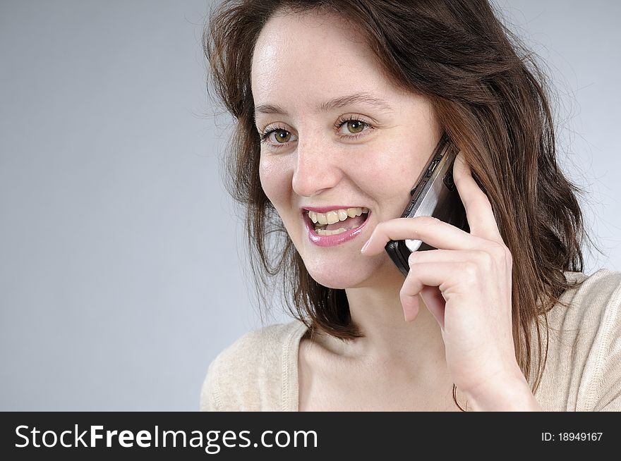 Cute caucasian girl talking on mobile and making gestures. Cute caucasian girl talking on mobile and making gestures
