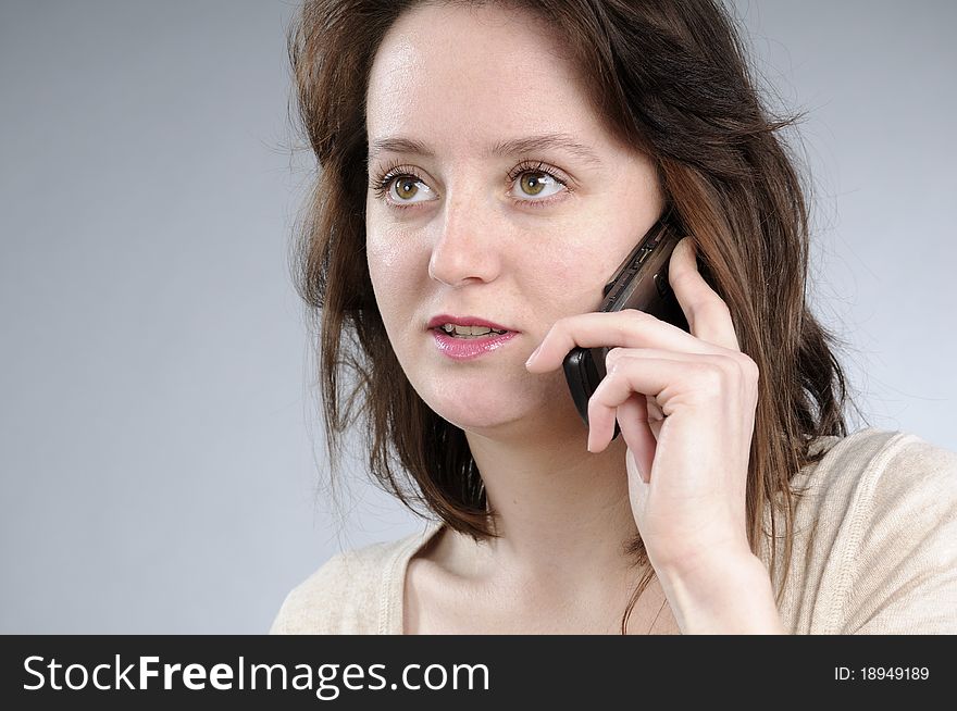 Cute caucasian girl talking on mobile and making gestures. Cute caucasian girl talking on mobile and making gestures