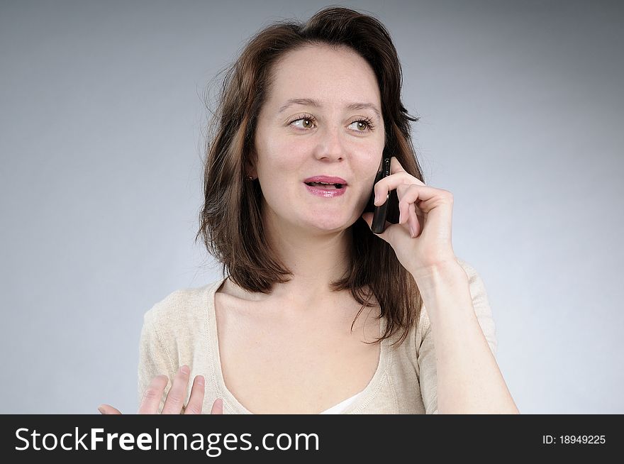 Cute caucasian girl talking on mobile and making gestures. Cute caucasian girl talking on mobile and making gestures