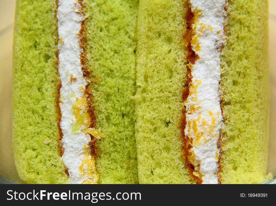 A slice of sponge Pandan cake on white background