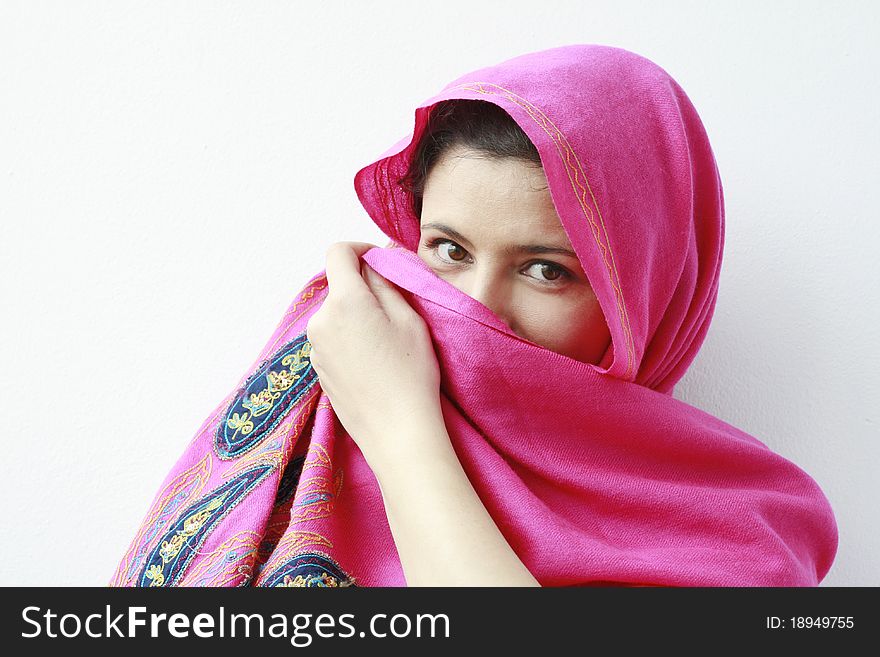 Arabian woman covering her face with a pink scarf