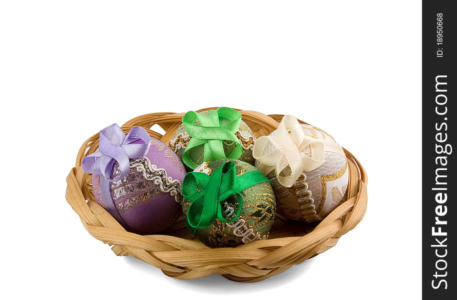 Four Easter eggs in a basket isolated on white