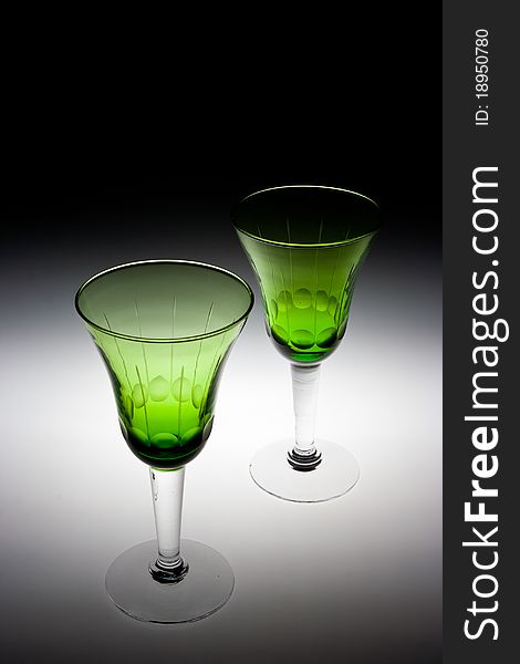 An image of two green glasses used for wine