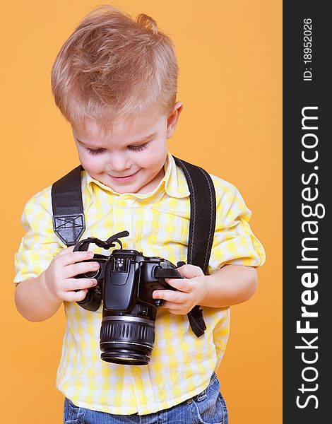 Little smiling photographer watching photo on professional camera. Little smiling photographer watching photo on professional camera