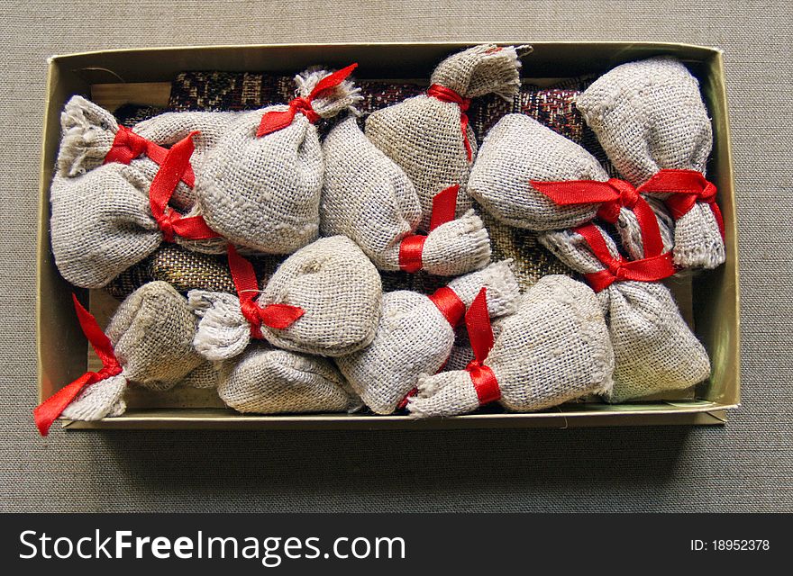 Small gifts in linen bags with red ribbons