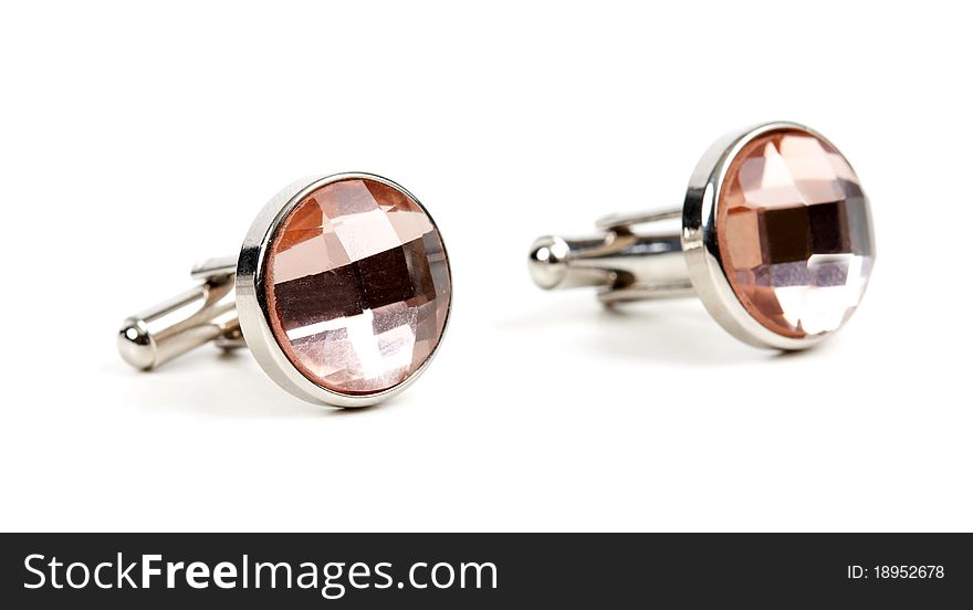 Pair of platinum cufflinks with a pink stone isolated on white background