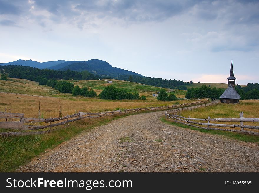 Beautiful scenery at evening from a countryside land with country road and a small old church. Beautiful scenery at evening from a countryside land with country road and a small old church.