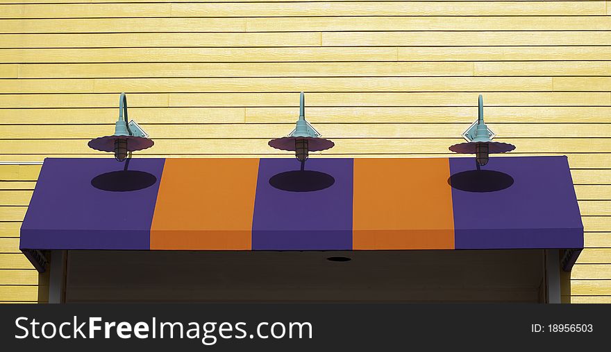 Lights show their shadows on the coloful business awning. Lights show their shadows on the coloful business awning