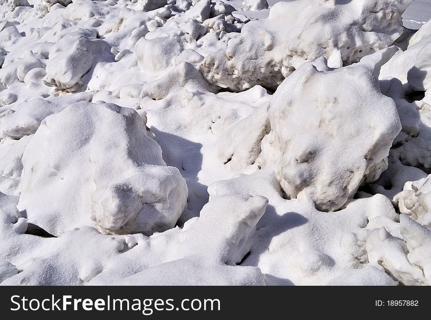 Dirty snow lumps background on roadside, sunny winter day. Dirty snow lumps background on roadside, sunny winter day