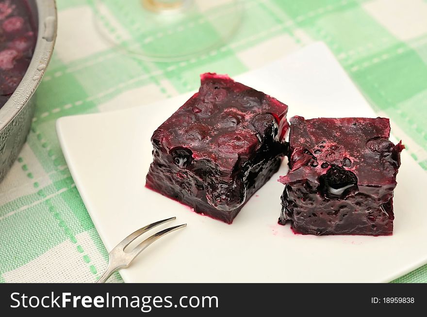 Red jelly cubes on white plate. Made from healthy fruits and berries. Red jelly cubes on white plate. Made from healthy fruits and berries.