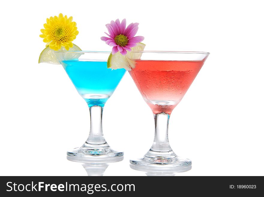 Tropical martini Cocktails row with vodka, light rum, gin, tequila, blue curacao, lime juice, lemonade, lemon slice and fresh summer flowers in martinis cocktail glass on a white background. Tropical martini Cocktails row with vodka, light rum, gin, tequila, blue curacao, lime juice, lemonade, lemon slice and fresh summer flowers in martinis cocktail glass on a white background