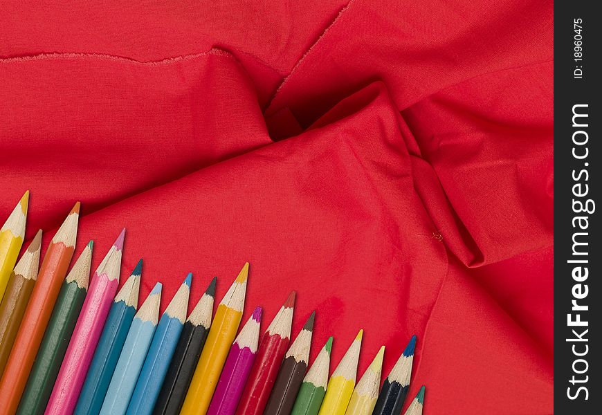 Colour pencils on a red tissue background