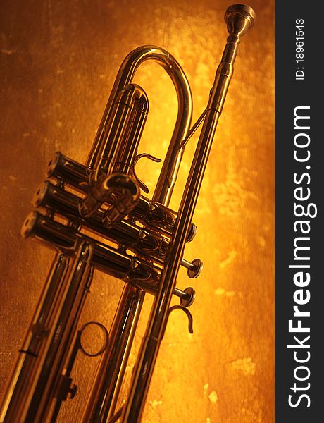 Brass trumpet horn on a golden background. Soft light and focus photograph.