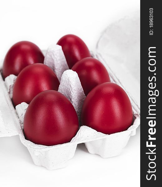 Six boiled red eggs in a cardboard on a white background