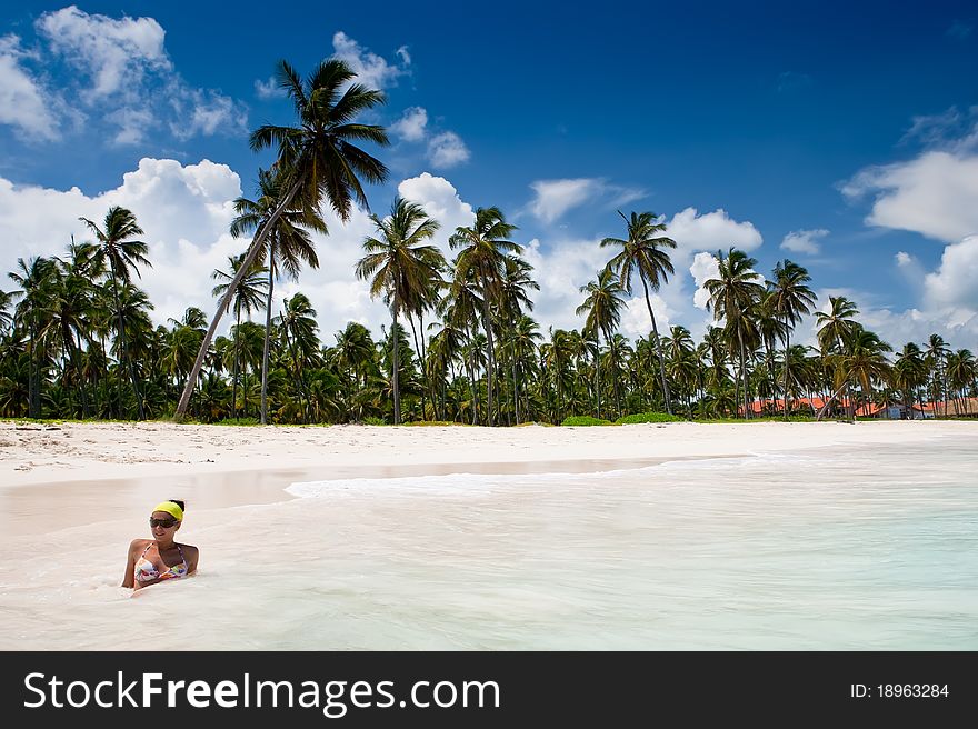 Beautifull women and Green palms on white sand beach under blue sky near sea