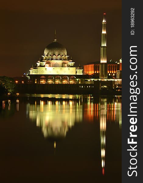 Night view of Putra Mosque with reflection on water.