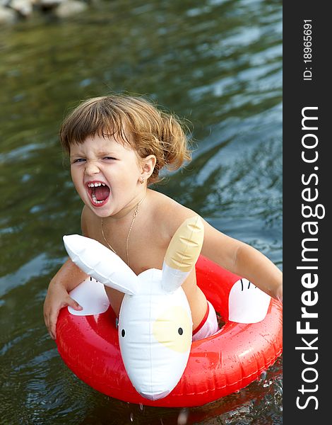 Little girl swims in sea in an red life preserver. Little girl swims in sea in an red life preserver