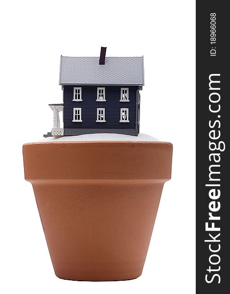 Model of the house on the sand falling asleep in a ceramic flower pot. Model of the house on the sand falling asleep in a ceramic flower pot.