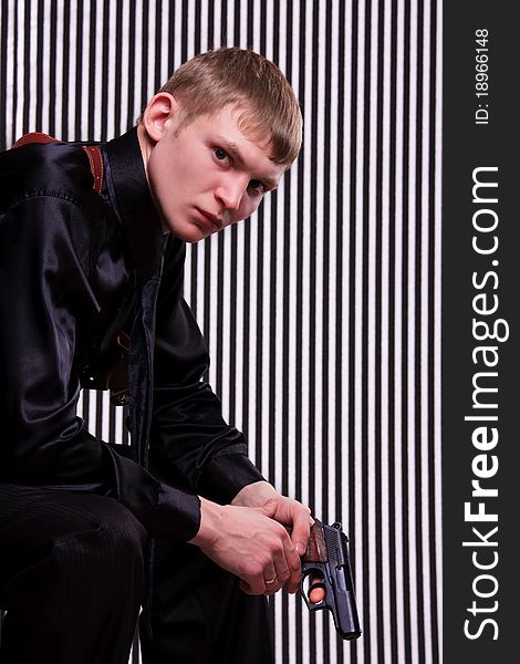 Serious man with a gun against striped background