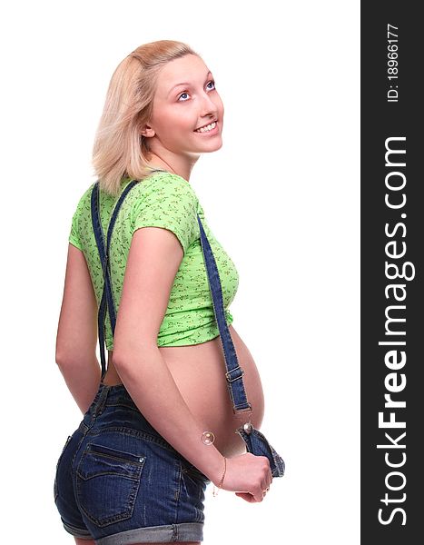 Young pretty pregnant woman posing in jeans overalls