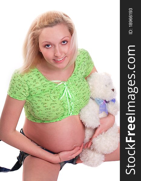 Cute pregnant girl sitting with teddy bear