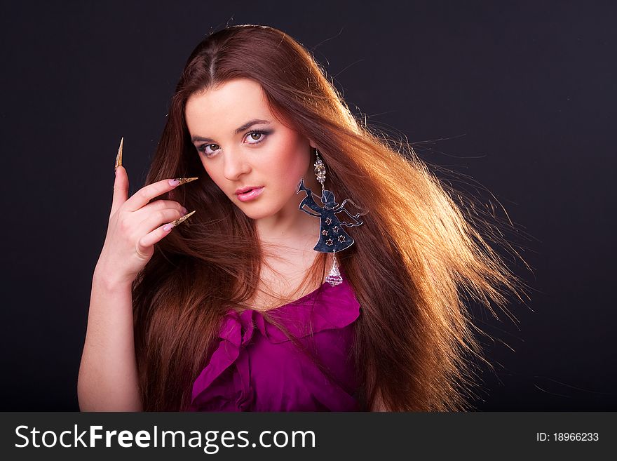 Beautiful long-haired brunette in a dress of fuchsia with sparkle earring. Beautiful long-haired brunette in a dress of fuchsia with sparkle earring