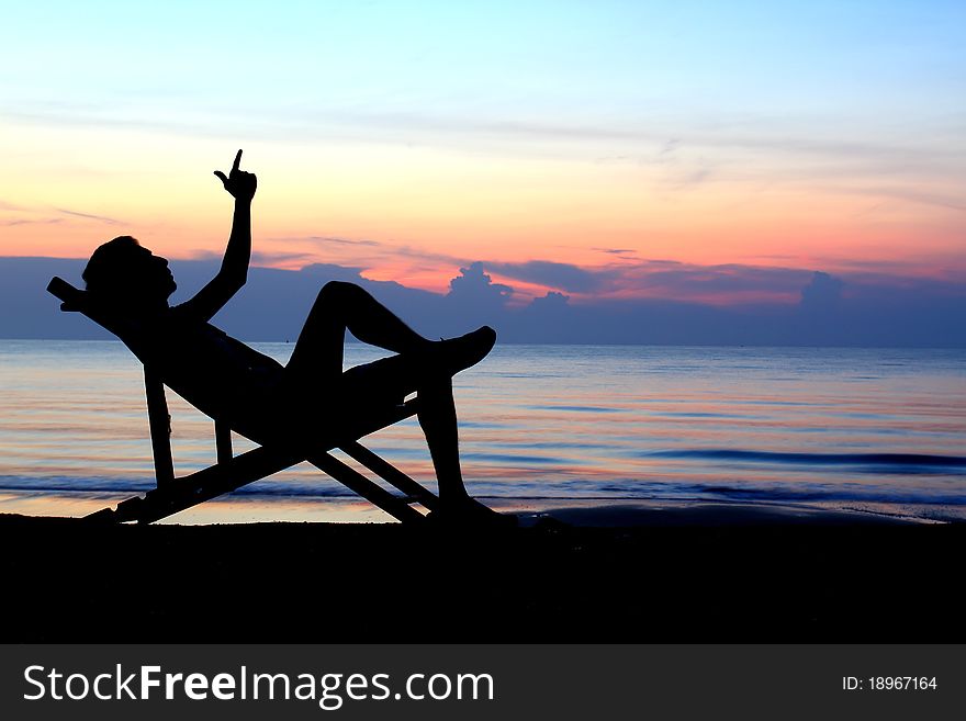 Couple stretching in deckchairs at sunset. Couple stretching in deckchairs at sunset