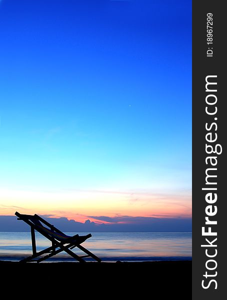 One Deckchairs On Beach At Sunset