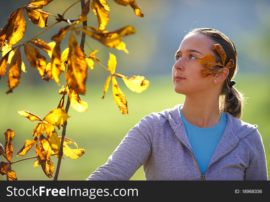 Young girl throws leaves