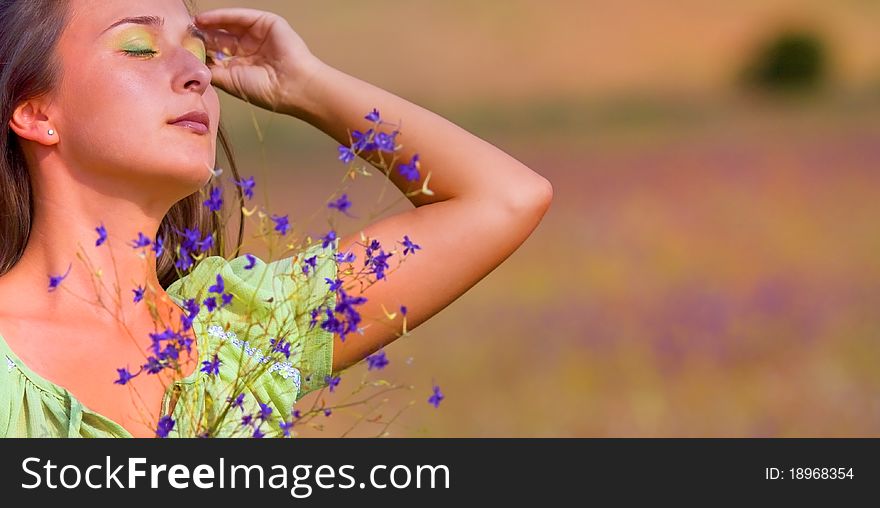 Young beautiful woman on field in summer