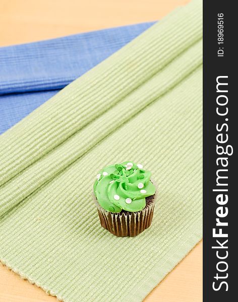 Green Frosting Chocolate Cupcake On Green Mat. Green Frosting Chocolate Cupcake On Green Mat
