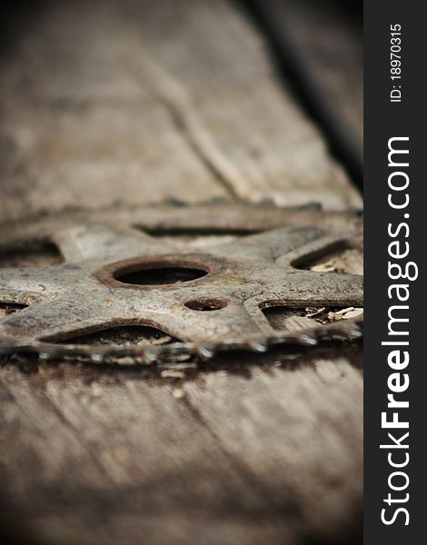 Just a unique view of an old bicycle sprocket laying on an old barn door.