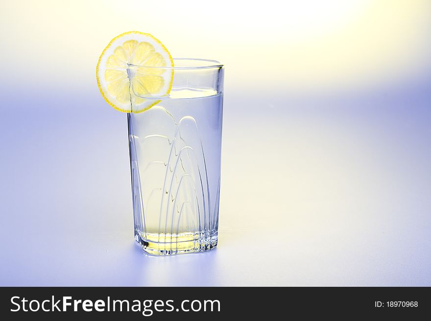 Lemon Water studio shot with slice of lemon on the edge of the glass