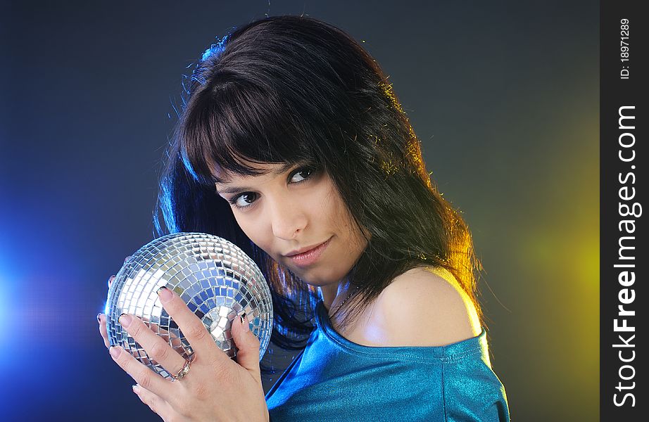 Portrait of beautiful young brunette with disco ball