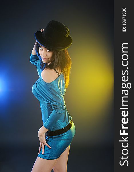 Beautiful young woman in blue dress and black hat. Beautiful young woman in blue dress and black hat