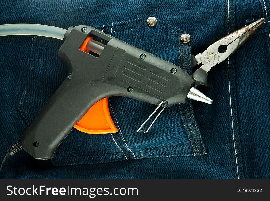 Blue jeans and tools in pocket (glue gun and plier).